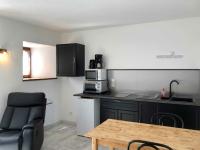 a small kitchen with a table and a microwave at Auberge Les Grillons in Meyras