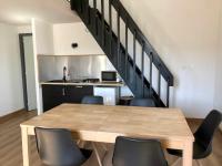 a dining room with a table and chairs and a staircase at Auberge Les Grillons in Meyras