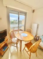 a dining room with a table and chairs and a window at Appart ESTIVALE pr 4pax Acces plage in Saint-Raphaël