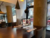 a computer monitor sitting on top of a wooden desk at citizenM New York Times Square in New York
