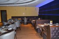 ein Esszimmer mit Tischen und Ledersesseln in der Unterkunft Sobti Continental Bareilly in Bareilly