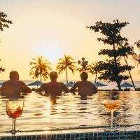 Eine Gruppe von Menschen sitzt mit Weingläsern in einem Pool. in der Unterkunft West Phu Quoc Charm 3BR private pool villa in Phu Quoc