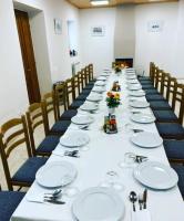 uma mesa longa numa sala com cadeiras e pratos em Hotel Vermoshi TDC em Vermosh