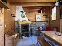 a living room with a stone fireplace and a table at Chalet la Grande Motte in Champagny-en-Vanoise
