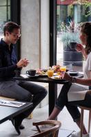 a man and woman sitting at a table eating food at Hotel Valkenburg by Mercure - Next to Shimano Experience Center in Valkenburg