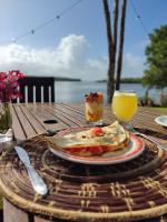 サントアンドレにあるPousada ORIBÁの食べ物の皿とオレンジジュースのグラスが置かれたテーブル