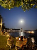 サントアンドレにあるPousada ORIBÁの夜、水辺のテーブルに座っている人々のグループ