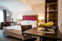 a hotel room with a bed and a table with a bowl of fruit at Point Hotel Apartments and Rooms in Dresden