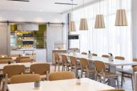 サンノゼにあるElement San Jose Airportのテーブルと椅子とキッチンのあるレストラン