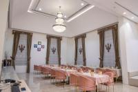 une salle de banquet avec des tables, des chaises et un lustre dans l'établissement The Utopia Resort Sanchi, à Sānchi