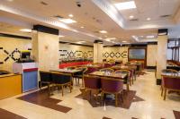 Un restaurante con mesas y sillas en una sala. en Three 888 Hotel, en Dubái