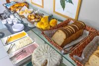a glass table topped with lots of different types of bread at Pousada Boulevard in Cabo Frio