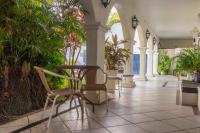 a hallway with chairs and plants in a building at Pousada Boulevard in Cabo Frio