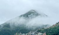 a mountain in the fog with houses and buildings at Jiufen Breeze 九份惠風民宿ｌ6人包棟小屋 in Jiufen
