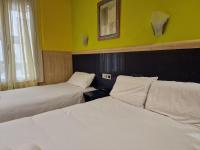 A bed or beds in a room at Pension Izar Bat Guesthouse