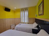 A bed or beds in a room at Pension Izar Bat Guesthouse