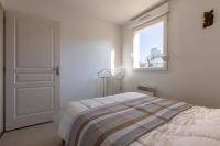 a white bedroom with a bed and a window at LaConciergerieJonzac, Appartement La Désirade in Jonzac