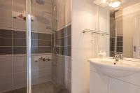 a white bathroom with a sink and a shower at LaConciergerieJonzac, Appartement La Désirade in Jonzac