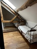 a bedroom with a bunk bed in a attic at Gîte des 3 Marchands in Buzançais