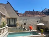 a house with a swimming pool in front of a building at Gîte des 3 Marchands in Buzançais