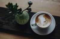 een kopje koffie zittend op een tafel bij Fischer Apartments in Oberammergau