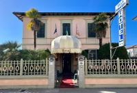 un edificio con una puerta y un edificio con palmeras en Hotel Villa Primavera, en Pisa