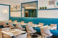 uma fileira de mesas e cadeiras em um restaurante em NH Coimbra Dona Ines em Coimbra