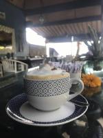 een kop koffie op een schotel op een tafel bij Spacious Private Pool Apartment-Beachside Resort in Candidasa