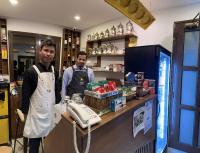 two men standing behind a counter with a telephone at منتجع اووه يامال البحري في الخيران OOh Yaa Mal in Al Khīrān