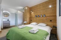 a bedroom with a large bed with a wooden wall at Appartement Flégère et Golf - Happy Rentals in Chamonix