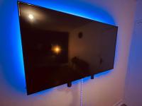 a flat screen tv hanging on a wall with blue lights at Appartement Prestige - Amiens in Amiens