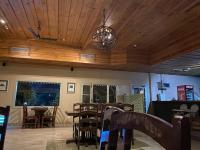 Un comedor con techos y mesas de madera y una lámpara de araña. en Hotel Sarai Bharatgarh, en Chandīgarh