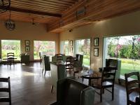 Un comedor con mesas y sillas y ventanas. en Hotel Sarai Bharatgarh, en Chandīgarh