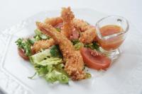 ein Teller mit Essen, Salat und frittierten Calamari in der Unterkunft Lila Medical SPA in Ciechocinek