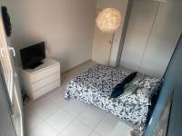 a small bedroom with a bed and a tv at Appartement T3 climatisé,balcon in Le Boulou