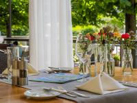 a table with plates and glasses and flowers on it at Landgasthof Seelust in Egnach