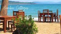 a group of chairs and tables on the beach at Bamboo Cottages in Phu Quoc