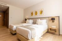Un dormitorio con dos camas con almohadas blancas. en Golden Tulip Opera Alger, en Argel
