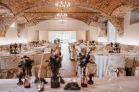 un salón de banquetes con mesas con flores en jarrones en Schloss Gamlitz, en Gamlitz