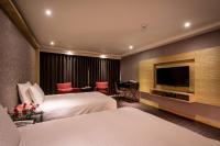 a hotel room with two beds and a flat screen tv at Chateau-Rich Hotel in Tainan