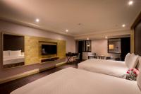 a hotel room with two beds and a flat screen tv at Chateau-Rich Hotel in Tainan
