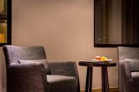 two chairs and a table with a bowl of fruit on it at Chateau-Rich Hotel in Tainan