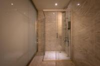 a shower with a glass door in a bathroom at Chateau-Rich Hotel in Tainan