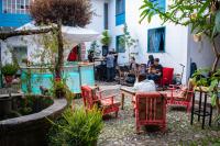 a group of people sitting at a table in a garden at Inkarri Cusco in Cusco