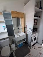 a bathroom with a toilet and a sink and a washing machine at Le Studio de Jo in Cayenne
