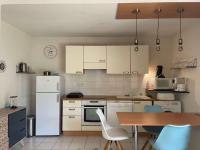 a kitchen with white appliances and a table and chairs at Appartement Capbreton, 2 pièces, 4 personnes - FR-1-239-872 in Capbreton