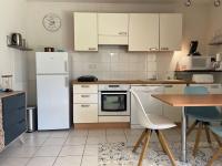 a kitchen with white appliances and a wooden table at Appartement Capbreton, 2 pièces, 4 personnes - FR-1-239-872 in Capbreton