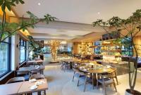 ein Restaurant mit Tischen und Stühlen und eine Bar in der Unterkunft Percent Hotel Yangshuo in Yangshuo