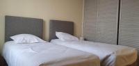 two beds in a bedroom with white sheets and pillows at Résidence Auger in Bourges