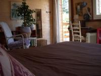 a bedroom with a bed and two chairs and a table at Un havre de paix in Aigues-Vives